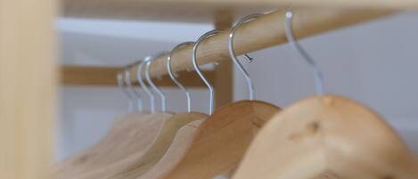 A wooden spoon rack with several wooden spoons hanging on it.