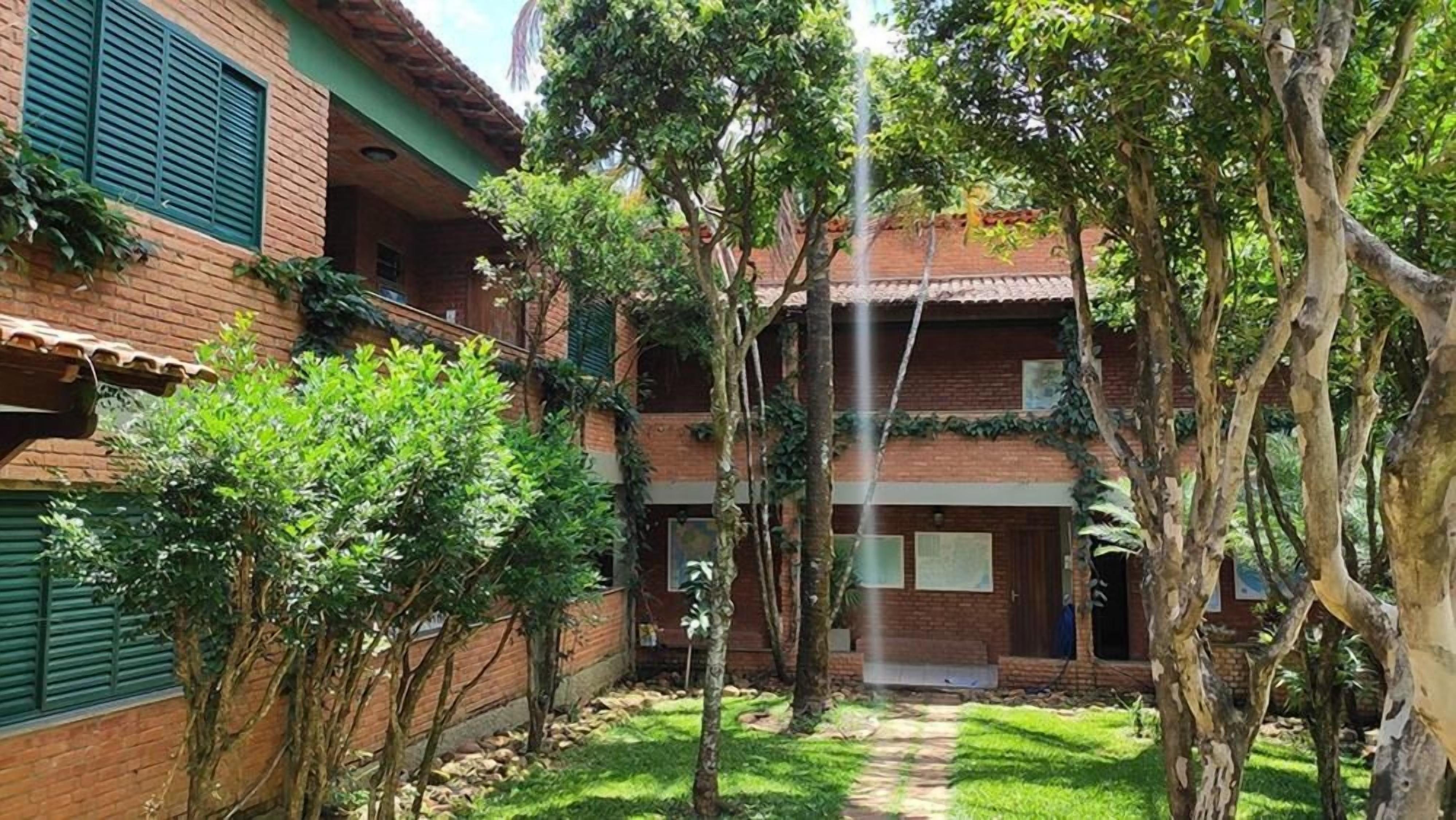 A courtyard with a brick building, trees, and a visible water feature.