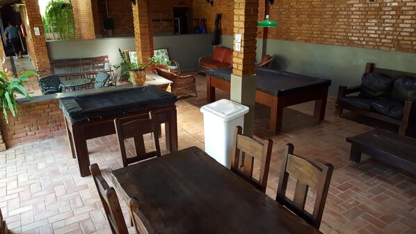 Un rincón exterior acogedor con paredes de ladrillo, muebles de madera y plantas en macetas.
