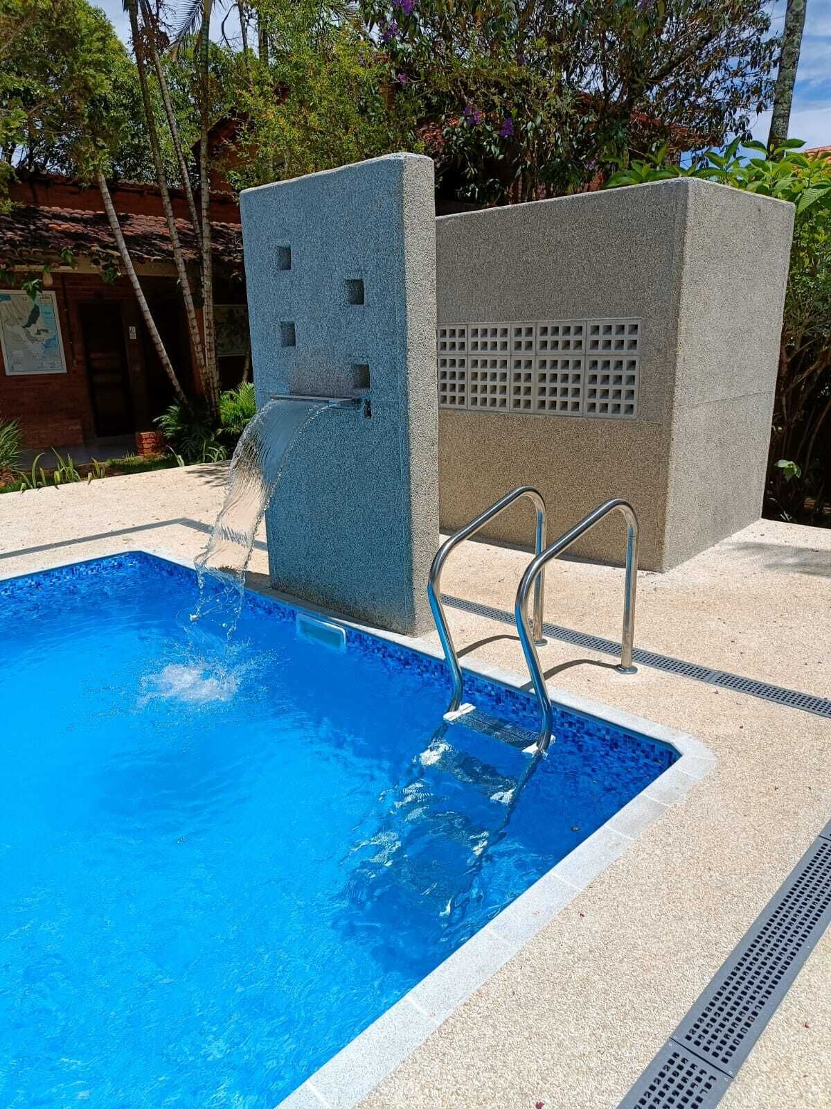 A swimming pool with a built-in diving platform and a metal ladder.