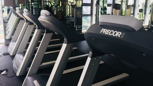 A row of treadmills in a gym with mirrors on the walls.