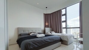 A modern bedroom with a large bed, a side table, and a view of the city through a large window.