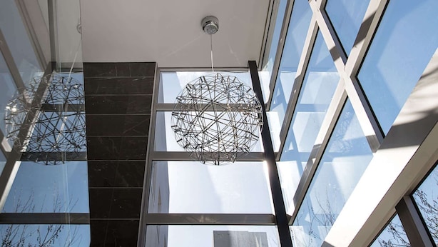 A modern interior with large windows and a geometric ceiling structure.