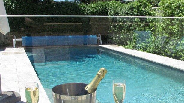 A swimming pool with a champagne bottle and glasses on a table. - IDEAL FAMILY BEACH GETAWAY, 1 HR FROM SYDNEY!!! (Umina Beach)