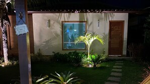 A covered outdoor area with a hammock, a welcome sign, a window, and a door. - Beautiful house in the best gated community in Manguinhos. (Armação dos Búzios)
