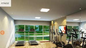A fitness room with treadmills, elliptical machines, and a TV screen.