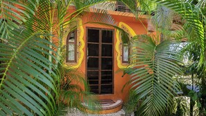 A small, colorful building with a central door, surrounded by lush greenery. - Montezuma Heights "Geco" studio. In between ocean and the wild. Sleeps 2 (Montezuma)