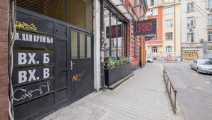 En byggnad med en svart dörr märkt med ”BX. B” och en röd skylt med texten ”Y20” på sidan.