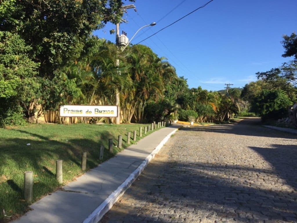 Una carretera pavimentada con un letrero que dice 'Praias de Bahia' y una acera con postes de madera.
