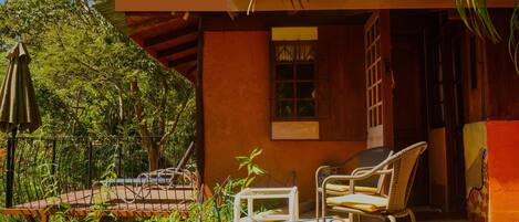 Une agréable terrasse extérieure avec une table et des chaises, entourée d’une végétation luxuriante.