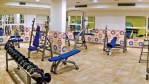 A gym with various exercise equipment, including benches and weight machines. - Kyklades Resort DPSBF04 -Colorful One Bed Apartment- WIFI-Communal Pool-Gym-Spa (Pralimni)