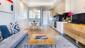 Una sala moderna con sofá, mesa de centro y una obra de arte en la pared.
