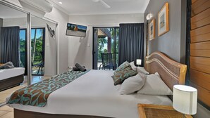 Ein modernes Hotelzimmer mit einem großen Bett, einem Deckenventilator, Blick ins Freie und einem Balkon.