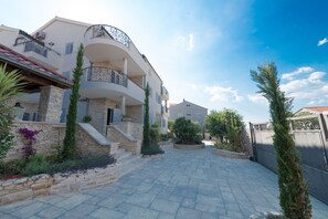 Guests can enjoy a balcony with a wrought-iron railing overlooking a tranquil courtyard with lush greenery.