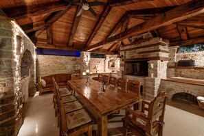 Cozy dining area with a large table and stone fireplace.