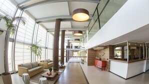A spacious lobby with a central walkway, seating areas, and a reception desk. - Flat high standard in the seaside paradise in Barra de São Miguel (Barra de São Miguel)