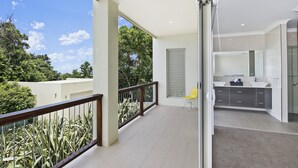 Eine moderne Wohnung mit Balkon, einer Küche mit großem Fenster und Blick ins Grüne.
