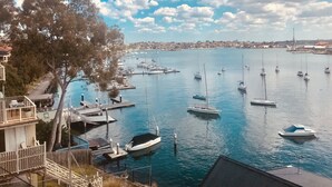 A marina with boats docked, a clear sky, and a distant cityscape. - The Abode - 2-3 bedrooms - premium, spacious, light-filled and harbour views (Birchgrove)