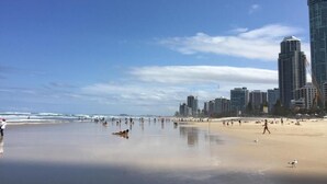 Une plage avec la silhouette d’une ville en arrière-plan.