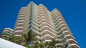 Un hôtel à plusieurs étages dont l’architecture présente un motif en zigzag, avec des balcons à chaque niveau.