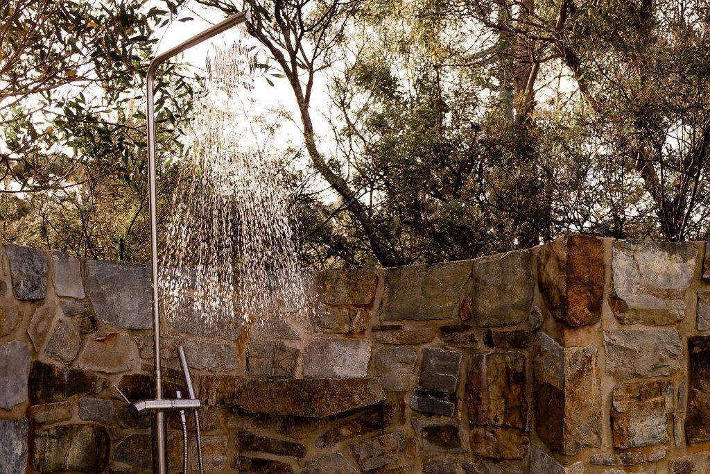 A stone wall with a showerhead.