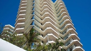 A high-rise hotel with a zigzag architectural design, multiple balconies, and a clear blue sky in the background. - Beautiful Beach Front Apart. sleep six available Dec 26th 2026 - Jan 9th 2027. (Coolangatta)