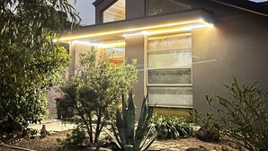 Ein modernes Haus mit flachem Dach, großen Fenstern und einer gut beleuchteten Außenansicht.