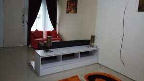 Una sala moderna con un mueble blanco para equipo multimedia, sofás rojos, un sofá negro y una alfombra estampada.