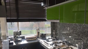 Une cuisine moderne équipée d’une cuisinière à gaz, d’un évier en acier inoxydable et de plans de travail en granit.