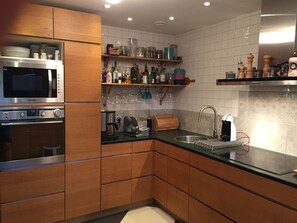 Enjoy cooking in this well-equipped kitchen with a refrigerator, oven, and sink.