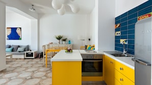 Une cuisine moderne avec des meubles de couleur jaune, un plan de travail blanc et un revêtement mural bleu.