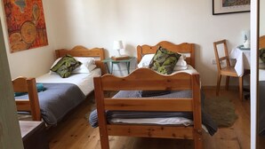 Une pièce confortable avec deux lits en bois, une petite table avec une lampe et une chaise.
