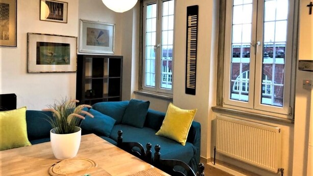 A cozy living room with a blue sofa, a wooden coffee table, and a potted plant. - Splendid 1 Bedroom Flat + Terrace (Kentish Town) (London)