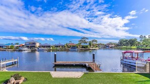 A marina with docked boats, a small dock, and houses in the background. - Canal Elegance in Yunderup (South Yunderup)