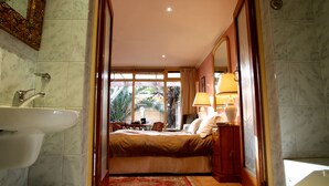 Une chambre d’hôtel avec un lit, une salle de bain avec un lavabo et une vue sur l’extérieur.
