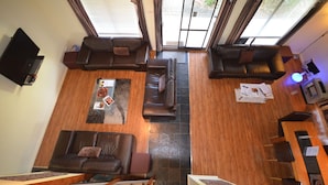 Un amplio salón con un gran sofá, una mesa de centro y un televisor.