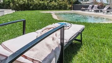 Un espace aménagé au bord de la piscine, avec des chaises longues et des serviettes.