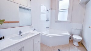 A modern bathroom with a white sink, bathtub, and toilet.