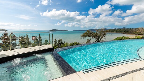 Une piscine avec vue sur la mer et les montagnes.