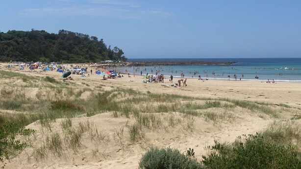 A beach with tents and people, sandy dunes, and a forested area in the background. - Self contained Top Unit - Surfs Up - Hear the sea at night. (Broulee)