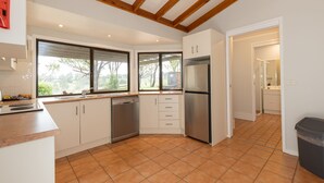 A kitchen with white cabinets, a stainless steel refrigerator, and a dishwasher. - The Cottage @ Hunter Gleann - Much more than the average cottage! (Pokolbin)