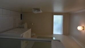 Et lille, moderne badeværelse med toilet, håndvask og håndklædestang.