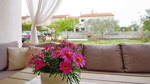 Un salon chaleureux avec un canapé et une table agrémentée d’un vase de fleurs roses.