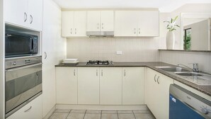 A kitchen with white cabinets, a built-in microwave, a gas stove, and a dishwasher.