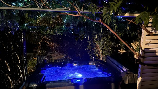 Ein Whirlpool, umgeben von Pflanzen und Lichterketten.