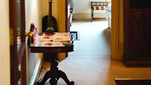 A hallway with a table, lamp, and a chair. - Fire Station Inn Penthouse Spa Apartment (North Adelaide)