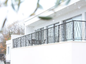 A modern building with a balcony and a tree logo. - A secluded house "La Finca OliveTree" (Šestanovac)