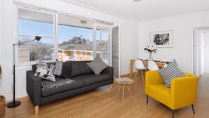 A modern living room with a sofa, a yellow armchair, and a coffee table. - Mosman BOT01 Botanic Rd-Balmoral 2BR Balcony Steps from Balmoral Beach Esplanade (Mosman)