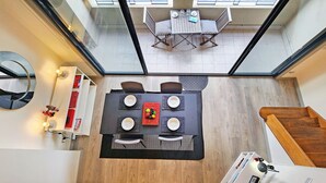 Ein modernes Interieur mit Essbereich, Treppe und Blick auf einen Balkon.