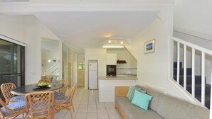 A modern interior with a dining area, kitchen, and living space. - Driftwood Mantaray Three Bedroom Loft (Douglas)